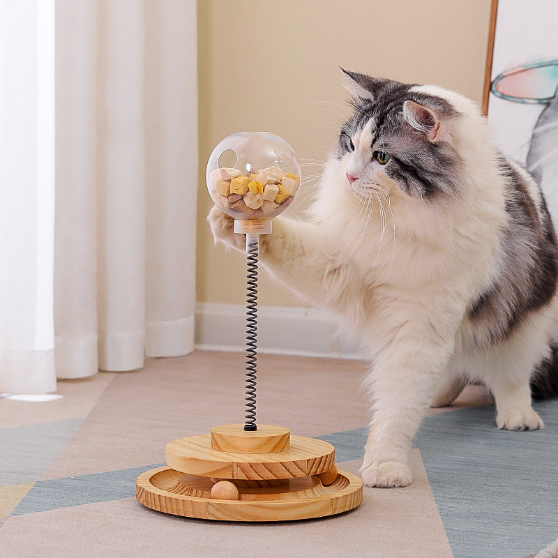 Cat Treats Dispenser Toy with spring-mounted clear ball filled with treats, wooden base, and interactive design for cats and small dogs.