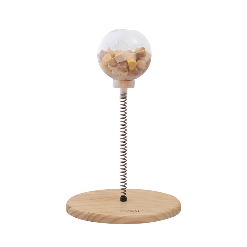 Cat Treats Dispenser Toy with spring-mounted clear ball filled with treats, wooden base, and interactive design for cats and small dogs.
